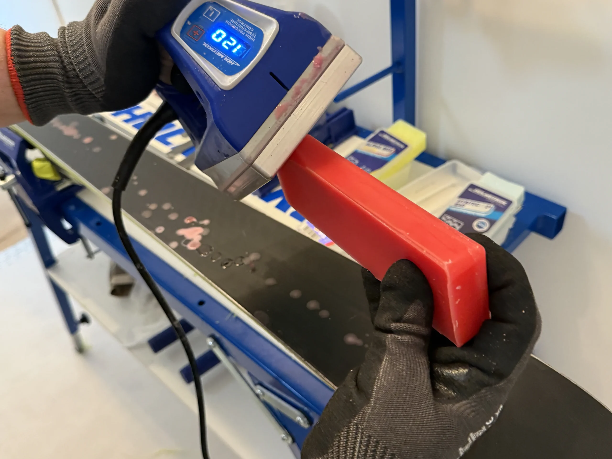 Hot wax druppelt op ski tijdens ski onderhoud in Terheijden