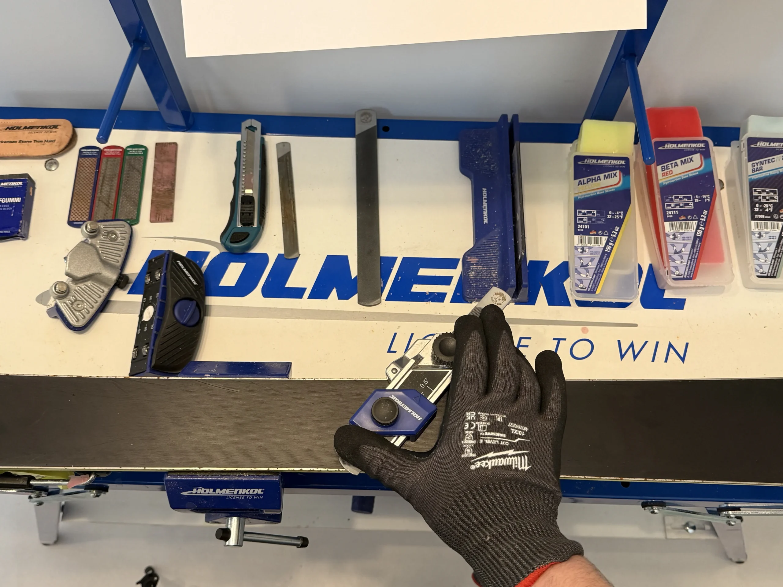 Staalkant van ski slijpen met vijl op werkbank
