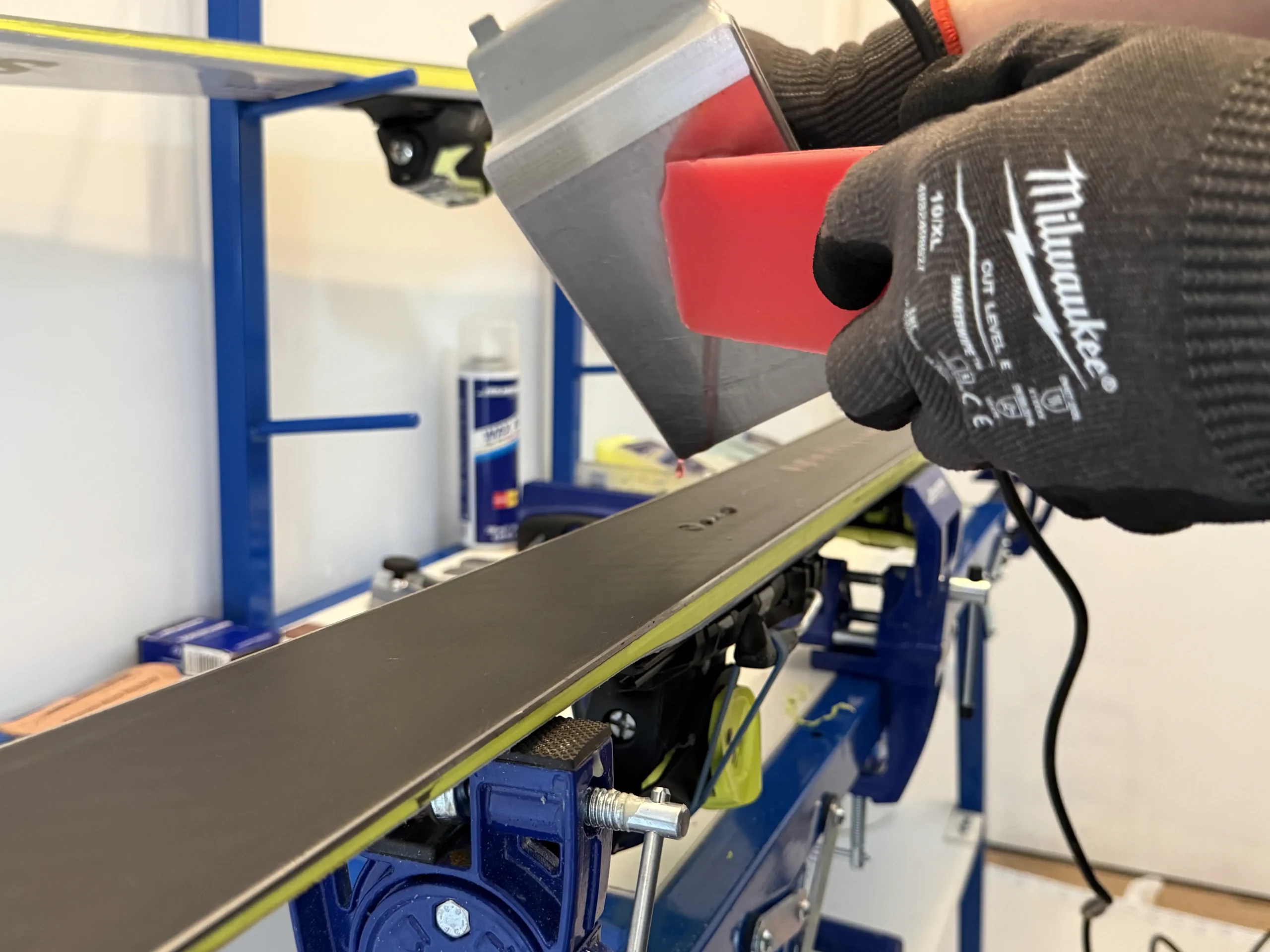 Hot wax druppelt op ski met waxijzer tijdens ski onderhoud voor Etten-Leur